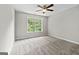 Carpeted bedroom with a ceiling fan and a view to the yard at 1429 Kentmire Court, Locust Grove, GA 30248