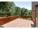 Wood deck with a dark brown railing on a two-story home with tree views at 1429 Kentmire Court, Locust Grove, GA 30248