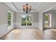 Bright dining room with large windows, a decorative chandelier, and beautiful molding detail at 1429 Kentmire Court, Locust Grove, GA 30248