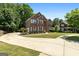 Beautiful two-story brick home with a circular driveway and lush landscaping at 1429 Kentmire Court, Locust Grove, GA 30248