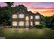 Charming brick home with a well-maintained lawn and colorful sunset backdrop at 1429 Kentmire Court, Locust Grove, GA 30248