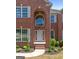 Grand front entrance with arched doorway, brick accents, and manicured landscaping at 1429 Kentmire Court, Locust Grove, GA 30248
