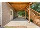 Covered patio under a wood deck with a white door and staircase leading to the upper level at 1429 Kentmire Court, Locust Grove, GA 30248