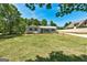 Front yard view of charming home, well-maintained lawn and surrounding mature trees at 203 Brannan Rd, Mcdonough, GA 30253