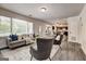 Open-concept living room featuring large windows, gray sofa, chairs, and laminate floors at 203 Brannan Rd, Mcdonough, GA 30253