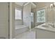 Bright bathroom features a soaking tub, glass enclosed shower, and dual vanities with generous windows at 100 Concord Ct, Fayetteville, GA 30214