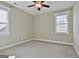 Well-lit bedroom featuring neutral walls, carpet, ceiling fan, and two windows at 100 Concord Ct, Fayetteville, GA 30214