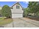 Attached garage with white door, concrete driveway, and manicured landscaping provides convenient parking at 100 Concord Ct, Fayetteville, GA 30214