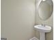Stylish powder room showcases a modern pedestal sink and a sleek, round mirror at 100 Concord Ct, Fayetteville, GA 30214