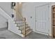 Indoor staircase with wooden handrail and white risers, leading to a white door, and a clock hung overhead at 100 Concord Ct, Fayetteville, GA 30214