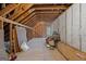 An unfinished attic features exposed beams, wall insulation, and natural light from a window at 9274 Betony Wood Trl, Jonesboro, GA 30236