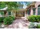 Brick pathway in backyard leads to a covered back porch area, surrounded by lush greenery at 9274 Betony Wood Trl, Jonesboro, GA 30236