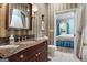 Classic bathroom with shower, marble vanity, decorative sconces and access to bedroom at 9274 Betony Wood Trl, Jonesboro, GA 30236