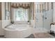 Bathroom featuring a corner tub, tiled shower and a double sink vanity with ample counter space at 9274 Betony Wood Trl, Jonesboro, GA 30236