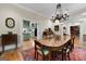 Dining room leading into the kitchen, featuring hardwood floors and a decorative chandelier at 9274 Betony Wood Trl, Jonesboro, GA 30236