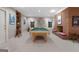 Spacious game room featuring a classic billiard table, brick fireplace, and a cozy atmosphere for entertaining guests at 9274 Betony Wood Trl, Jonesboro, GA 30236