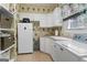 Bright laundry room featuring modern appliances, ample counter space, and floral wallpaper at 9274 Betony Wood Trl, Jonesboro, GA 30236