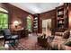 Elegant living room with rich wood paneling, built-in bookshelves, and a view to the dining room at 9274 Betony Wood Trl, Jonesboro, GA 30236
