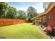 Spacious backyard with well-maintained lawn, mature trees, and a charming patio at 208 Summer Chase, Carrollton, GA 30116