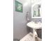 Cozy half bath featuring a pedestal sink, decorative mirror, gray walls and tasteful botanical wall art at 208 Summer Chase, Carrollton, GA 30116