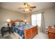Bedroom features a wooden bed frame with patterned bedding, a ceiling fan, and large window at 208 Summer Chase, Carrollton, GA 30116