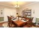 Dining room showcases a large wooden table with place settings, complemented by a decorative display shelf at 208 Summer Chase, Carrollton, GA 30116
