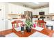 Bright kitchen with white cabinets, stainless steel appliances, granite countertops, and a view of dining table with flowers at 208 Summer Chase, Carrollton, GA 30116