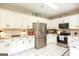 Bright kitchen with white cabinets, stainless steel appliances, granite countertops, and tile flooring at 208 Summer Chase, Carrollton, GA 30116