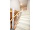 Bright and open staircase with carpeted steps, wooden railing, and a view into the dining room at 208 Summer Chase, Carrollton, GA 30116