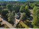 Aerial view of home surrounded by lush trees, highlighting its spacious lot, large driveway, and inviting curb appeal at 1875 Bernice Dr, Cumming, GA 30041
