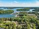 Expansive aerial showcasing the waterfront property near serene lake surrounded by verdant trees and boat docks at 1875 Bernice Dr, Cumming, GA 30041
