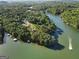 Captivating aerial view of waterfront properties featuring a serene lake with boat docks surrounded by lush greenery at 1875 Bernice Dr, Cumming, GA 30041