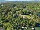 An aerial view of stunning waterfront property near a serene lake surrounded by lush, mature trees at 1875 Bernice Dr, Cumming, GA 30041