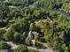 Aerial view of the property showcasing its location near a lake and surrounded by lush greenery and mature trees at 1875 Bernice Dr, Cumming, GA 30041
