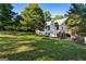 A spacious backyard featuring lush green lawn, mature trees, and stairs up to a deck area at 1875 Bernice Dr, Cumming, GA 30041