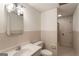 Bathroom featuring a single sink vanity, toilet, tiled shower, and neutral tile surround at 1875 Bernice Dr, Cumming, GA 30041