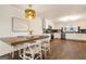 Dining area with a wood table and bright light fixture next to a modern kitchen at 1875 Bernice Dr, Cumming, GA 30041