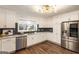 Bright kitchen with stainless appliances, white cabinets, and dark backsplash at 1875 Bernice Dr, Cumming, GA 30041