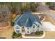 Aerial shot of a brick home with an attached trampoline featuring a well-maintained roof and spacious surroundings at 1202 Persimmon Way, Mcdonough, GA 30252