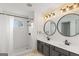 Bathroom features a double sink vanity with round mirrors and a shower at 1202 Persimmon Way, Mcdonough, GA 30252