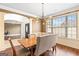 Stylish dining room with modern chandelier, rich wood floors, and a view of the front yard at 1202 Persimmon Way, Mcdonough, GA 30252