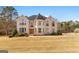 Stately two-story home with a brick exterior, many large windows, and a sprawling front yard at 1202 Persimmon Way, Mcdonough, GA 30252