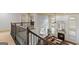Upstairs railing overlooking the main living space featuring fireplace and natural light at 1202 Persimmon Way, Mcdonough, GA 30252