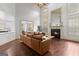 Open-concept living room with hardwood floors, fireplace and ample light from surrounding windows at 1202 Persimmon Way, Mcdonough, GA 30252
