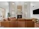 Bright living room featuring a fireplace, large windows, and a comfortable leather sofa at 1202 Persimmon Way, Mcdonough, GA 30252