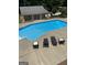 Inviting backyard pool with lounge chairs and a covered patio area, perfect for outdoor entertaining at 1202 Persimmon Way, Mcdonough, GA 30252