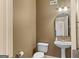 Neutral powder room including toilet and sink with view to a mirror and light fixture at 1202 Persimmon Way, Mcdonough, GA 30252