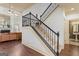 Elegant staircase with wrought iron railings, plush carpeting, and hardwood flooring that leads upstairs at 1202 Persimmon Way, Mcdonough, GA 30252