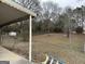Fenced backyard view with mature trees, storage shed and lots of foliage in the background at 2195 Wilson Nw Rd, Conyers, GA 30012