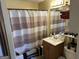 Standard bathroom with a single sink vanity, toilet, and a shower/tub with a striped curtain at 2195 Wilson Nw Rd, Conyers, GA 30012